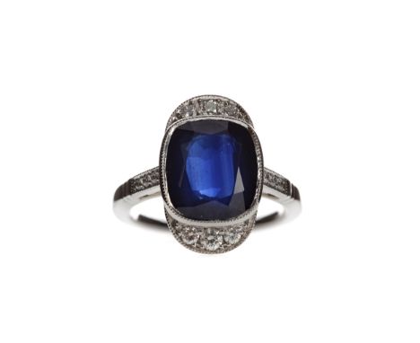 SAPPHIRE AND DIAMOND RING, set with a cushion cut sapphire of approximately 5.00 carats, flanked by round brilliant cut diamo