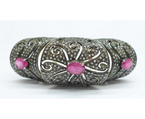 An articulated, double shank, full finger ruby and diamond set ring, set with many, approximately 400, small old cut diamonds