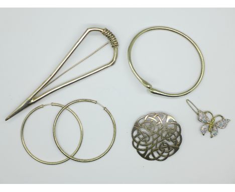 Two silver brooches, a butterfly brooch, a 925 silver bangle, and a pair of large silver hoop earrings 