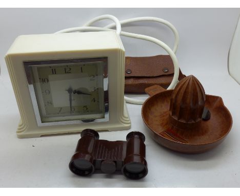 An ivory Bakelite electric mantel clock, a Bakelite orange squeezer, two scarf clips and a pair of opera glasses 