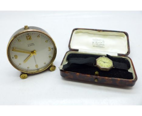 A Cyma Amic travel alarm clock and a lady's silver wristwatch, with boxes 