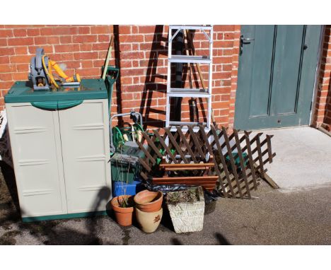A quantity of garden tools, a plastic storage cupboard, hose, aluminium step ladder, tool boxes etc