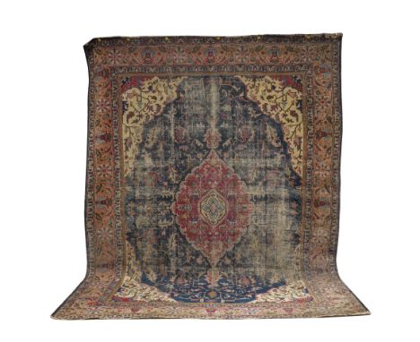 A TABRIZ CARPET, PERSIANThe indigo field with a bold shaped madder medallion, ivory spandrels, all with angular leaf vines; a