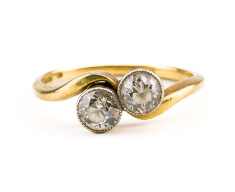 A GOLD AND DIAMOND TWO STONE RINGCollet set with two old cut cushion shaped diamonds in a crossover design, detailed 18 CT, r