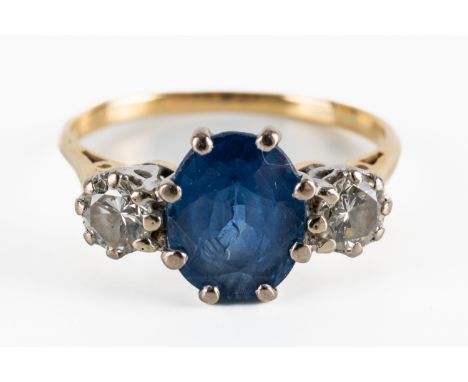 A GOLD, SAPPHIRE AND DIAMOND THREE STONE RINGClaw set with the oval cut sapphire between two round brilliant cut diamonds, de
