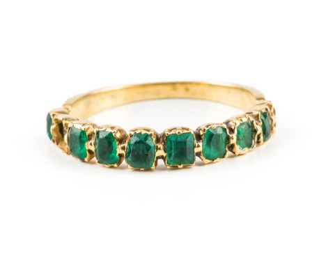 A GOLD AND EMERALD HALF HOOP RINGMounted with a row of nine variously cut emeralds (one emerald lacking), second quarter of t