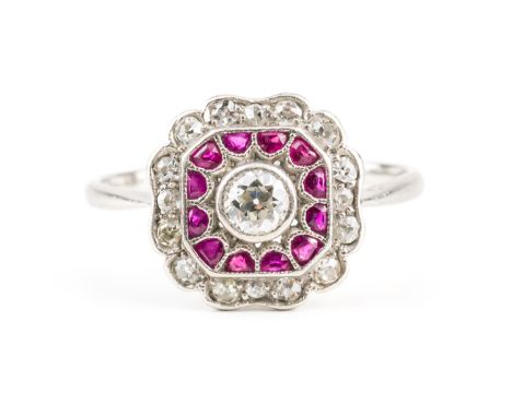 A PLATINUM, RUBY AND DIAMOND RINGCollet set with the principal cushion shaped diamond to the centre, within a ruby surround a