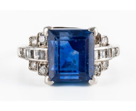 A SAPPHIRE AND DIAMOND RINGClaw set with the rectangular step cut sapphire between baguette and round brilliant cut diamond s