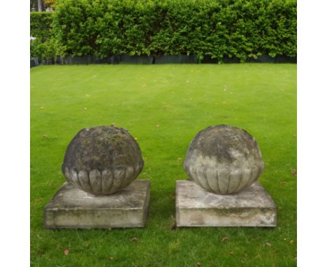 A PAIR OF RECONSTITUTED STONE SEMI GADROONED GATE PIER SPHERESOn square plinth bases, 43cm wide; 40cm high