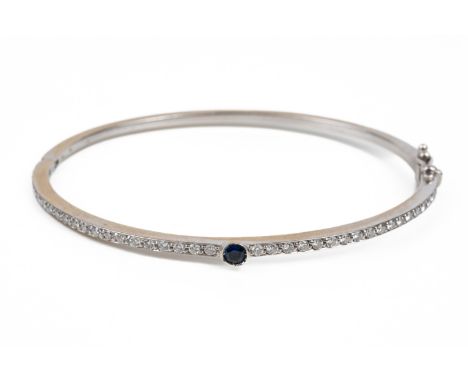A BLUE SAPPHIRE AND DIAMOND BANGLEThe top half of the bangle set with round brilliant cut diamonds and one bezel set round cu