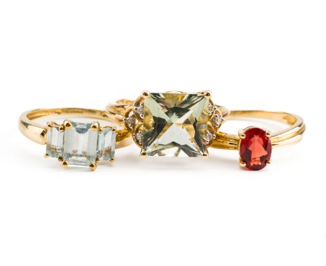 A 9CT GOLD AND AQUAMARINE THREE STONE RING AND TWO FURTHER 9CT GOLD AND GEM SET RINGS (3)The first ring claw set with the pri