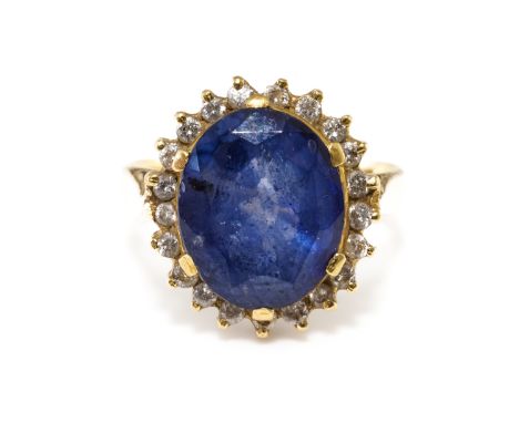 A SAPPHIRE AND DIAMOND CLUSTER RINGWith central claw set oval cut sapphire weighing an estimated 4.63 carats, with a surround