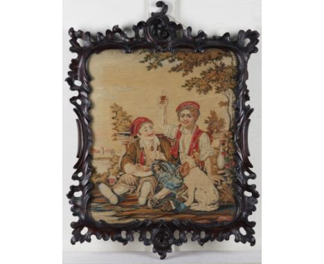 A VICTORIAN EMBROIDERED FIRESCREEN DEPICTING TWO CHILDREN (2)Mounted in a Rococo style carved oak frame, 70cm high; and an It