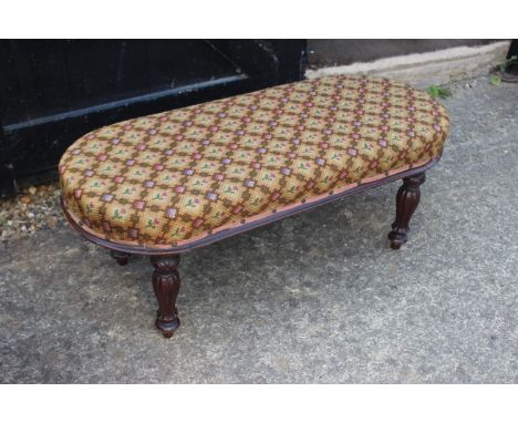 A Victorian mahogany oval top stool with floral tapestry seat on carved supports, 35" wide x 15" deep x 14" high 