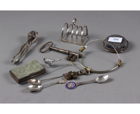 A shagreen silver gilt cigarette case (damages), three silver souvenir spoons, a silver toast rack, a model silver pheasant, 