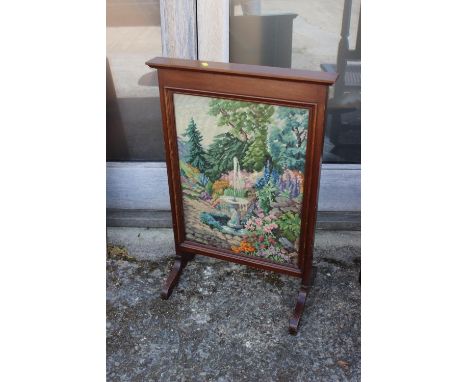 A walnut framed embroidered firescreen , on splay supports 