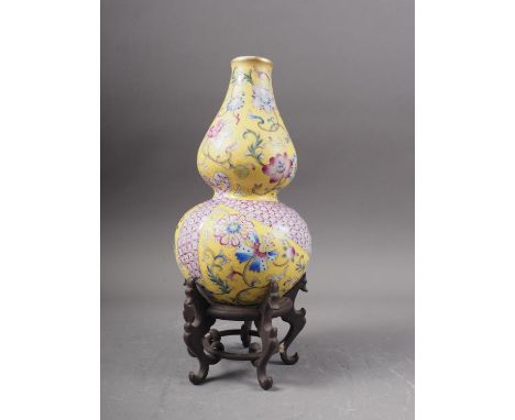 A Chinese double gourd vase with flower, fruit and geometric decoration on a yellow ground, 7 1/2" high, on associated hardwo