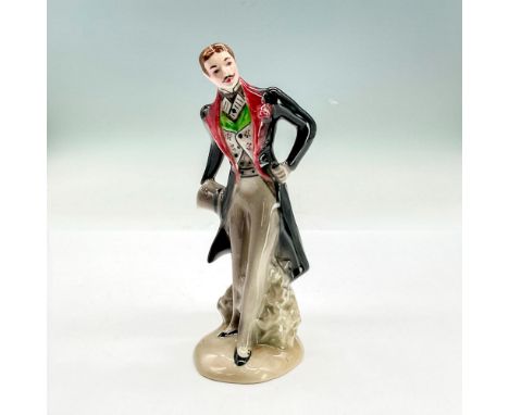 Glazed china figure of a dapper mustachioed gentleman in a black coat, colorful vest and grey pants holding a top hat. Goldsc