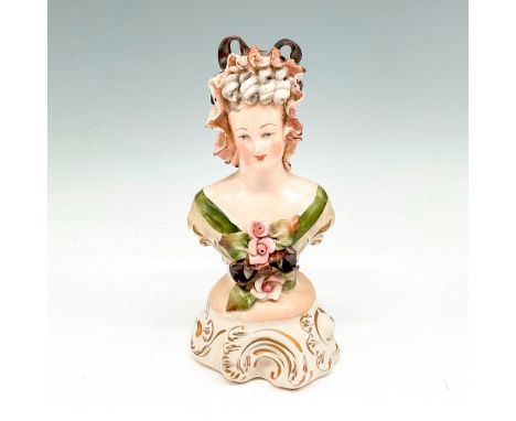 Figural portrayed with lace bonnet wearing shawl with floral accent in front. 3004. Issued: 20th centuryDimensions: 3.5"L x 3
