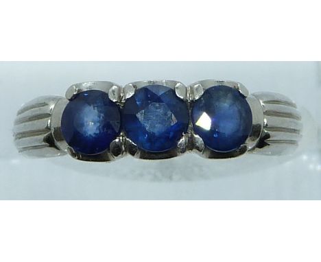 A white metal ring marked 900 set with three round cut sapphires, 6.6g, size N/O