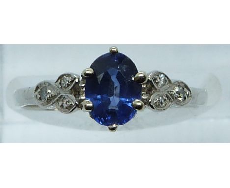 A platinum ring set with an oval cut sapphire of approximately 0.65ct and diamonds to the shoulders, 3.5g, size M/N