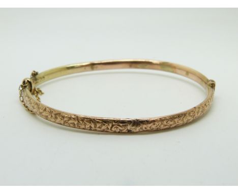 A 9ct rose gold bangle with engraved ivy decoration, 5.4g