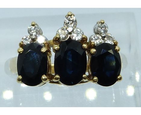 An 18ct gold ring set with three oval cut sapphires and diamonds, 6.6g, size K