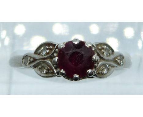 A platinum ring set with a round cut ruby of approximately 0.8ct and diamonds, 4.4g, size R