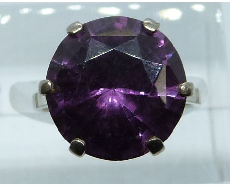 An 18ct white gold ring set with a round cut synthetic purple sapphire, 7.7g, size J/K