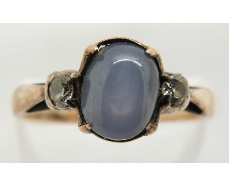 A yellow metal ring set with a star sapphire cabochon and two diamonds, 2.1g, size K