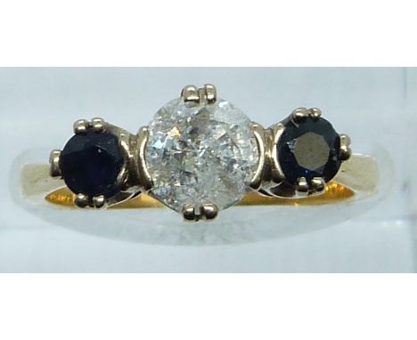 An 18ct gold ring set with a diamond of approximately 0.8ct and two sapphires, 3.9g, size M