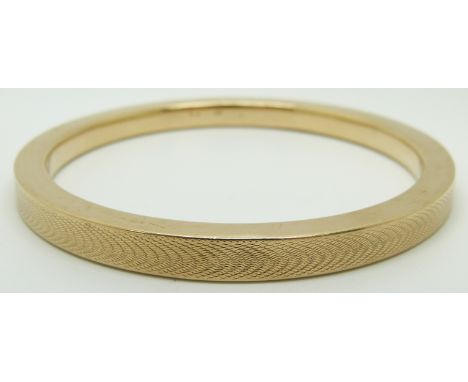 A 9ct gold flapper bangle with engine turned decoration, 18.8g