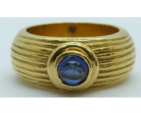 An 18ct gold textured ring set with a sapphire cabochon, 11.1g, size L