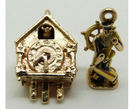A 9ct gold charm in the form of a cuckoo clock with movable hands and cuckoo and a 9ct gold charm in the form of a sailor pla