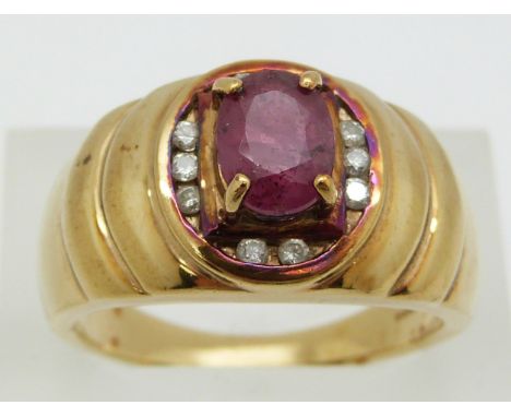 A 9ct gold ring set with an oval cut ruby and diamonds, 8.6g, size T/U