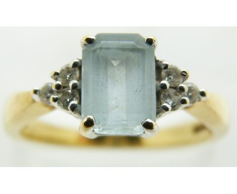 An 18ct gold ring set with an emerald cut aquamarine and diamonds, 3.9g, size N