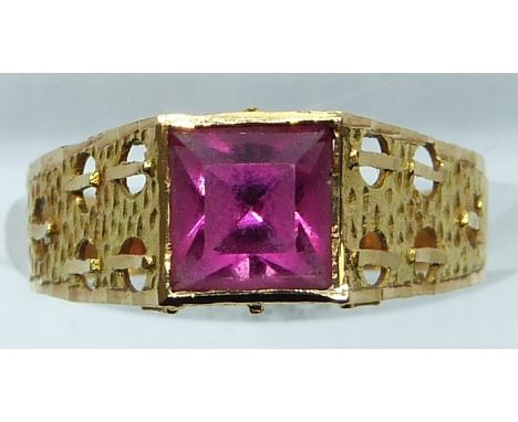 A yellow metal ring set with a square cut paste stone, 2g, size M
