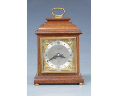 Elliott mantel clock in bell top mahogany case, the silvered Roman chapter ring with gilt cherub spandrels and signed Garrard