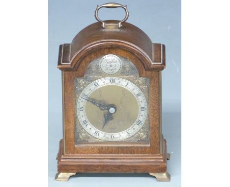 Elliott mantel clock in arched mahogany case, the silvered Roman chapter ring on bronzed dial with cherub spandrel decoration