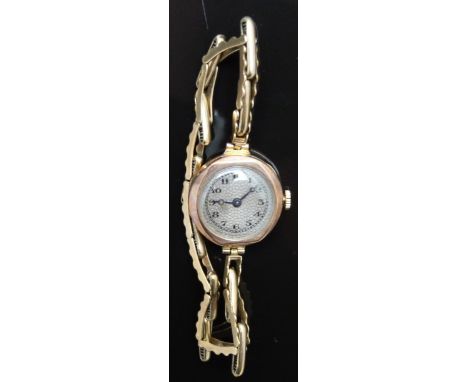 Vintage 9ct gold ladies wristwatch with blued Breguet hands, black Arabic numerals and patterned silver dial, on 9ct gold exp