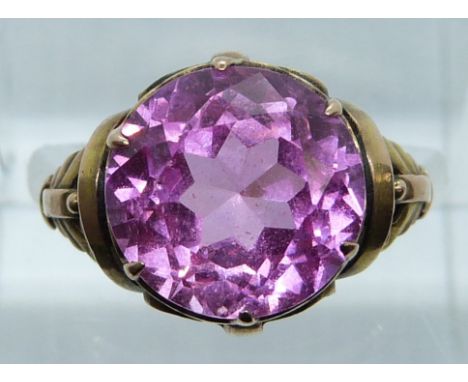 A 14k gold ring set with a round cut synthetic pink sapphire, 3.7g, size K/L