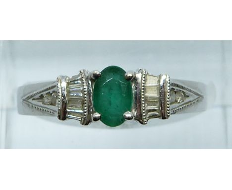 A 14ct white gold ring set with an oval cut emerald, round and baguette cut diamonds, 3.7g, size N/O