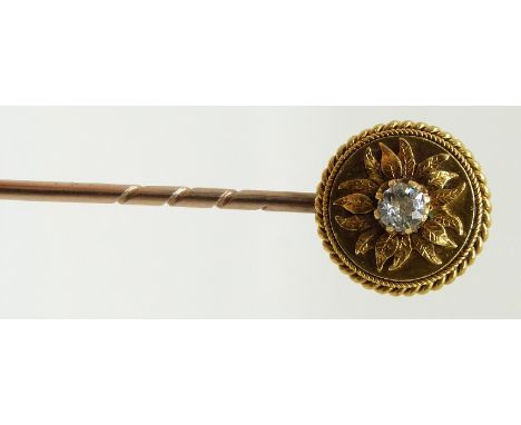 Victorian 18ct gold stick pin set with a diamond of approximately 0.15ct in a floral surround and rope twist border