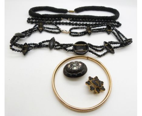 Victorian rolled gold flapper bangle, jet brooch inlaid with mother of pearl, French jet necklaces and a gilt brooch set with