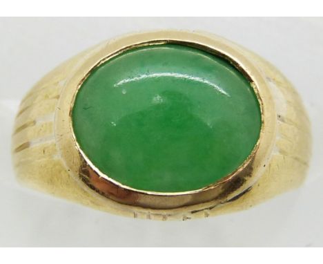A yellow metal ring set with a jadeite cabochon, 4.2g, size D/E