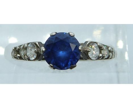 An 18ct gold ring set with a synthetic sapphire and paste, 2g, size P