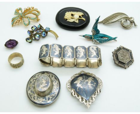 A collection of brooches including a jet example with ivory detail, silver, Siam silver and Thai example marked Thye Yiak Ban