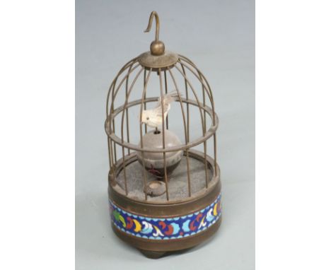 A c1950s bird-song automaton alarm clock, the case with cloisonné decoration to base, the orb dial with feathered bird over, 
