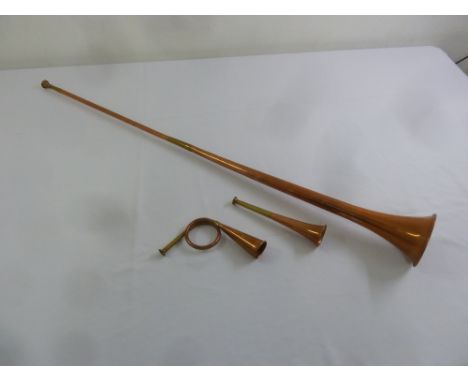 A brass and copper post horn and two brass and copper hunting horns