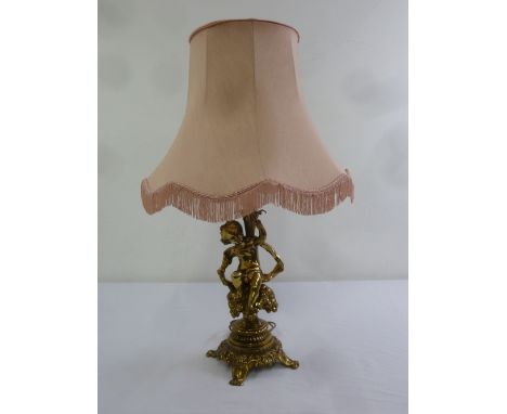 Gilded metal table lamp in the form of a putti with silk shade